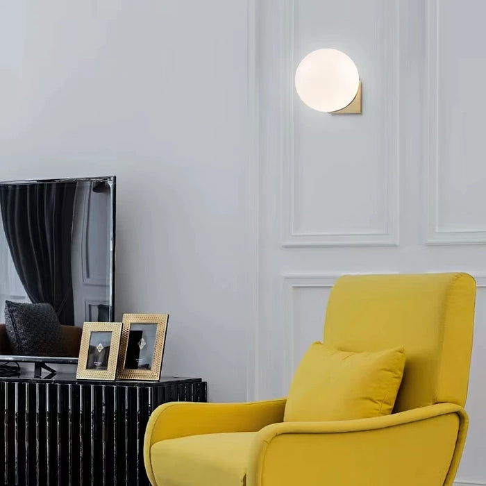 Solja – Nordic glass orb wall sconce in modern living room – gold single head above accent chair