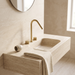 Kilde gold bathroom faucet on a floating travertine vanity with round mirror